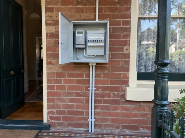 External switchboard on a brick wall beside a front entry and window in Newtown